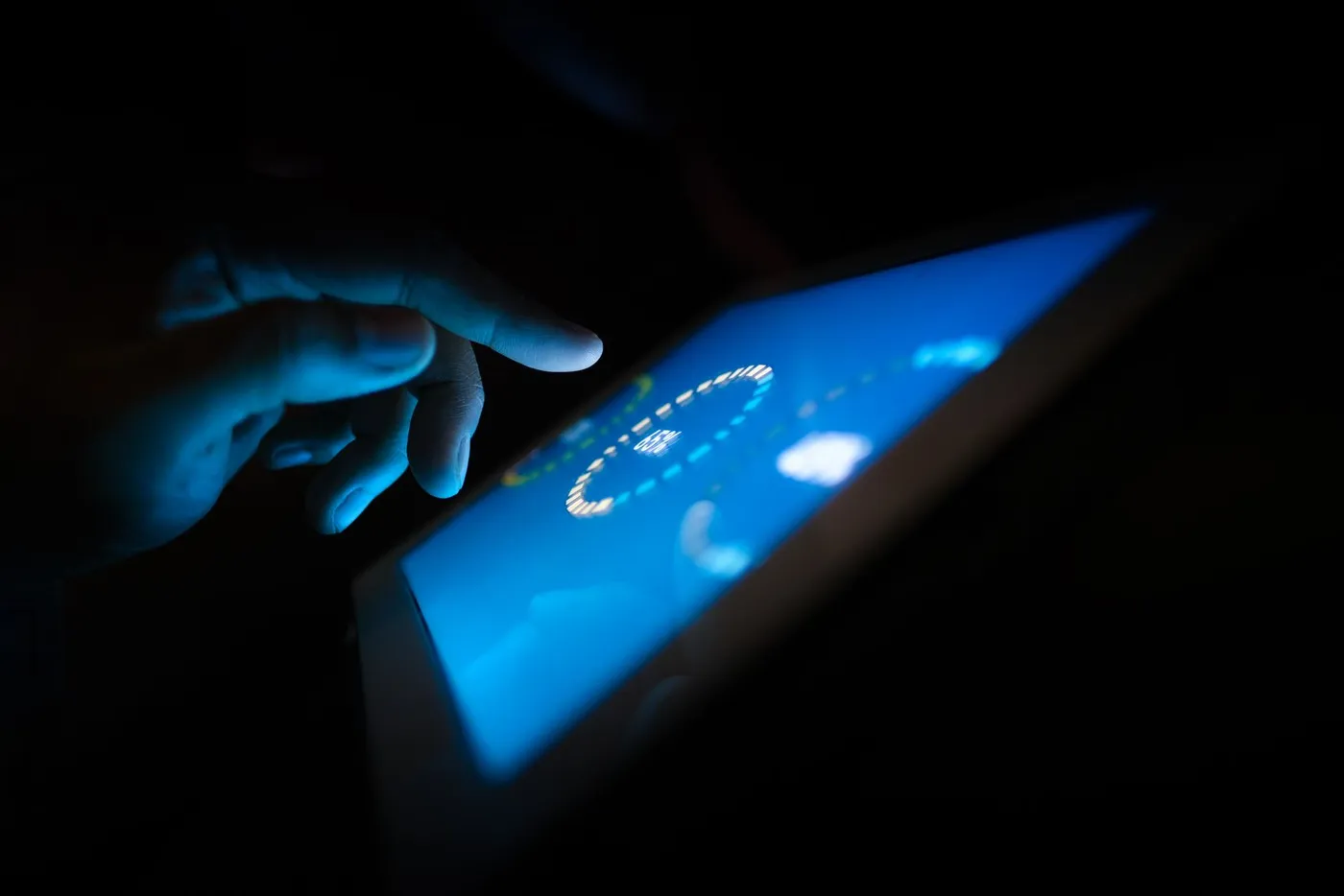 A hand tapping a glowing tablet dashboard